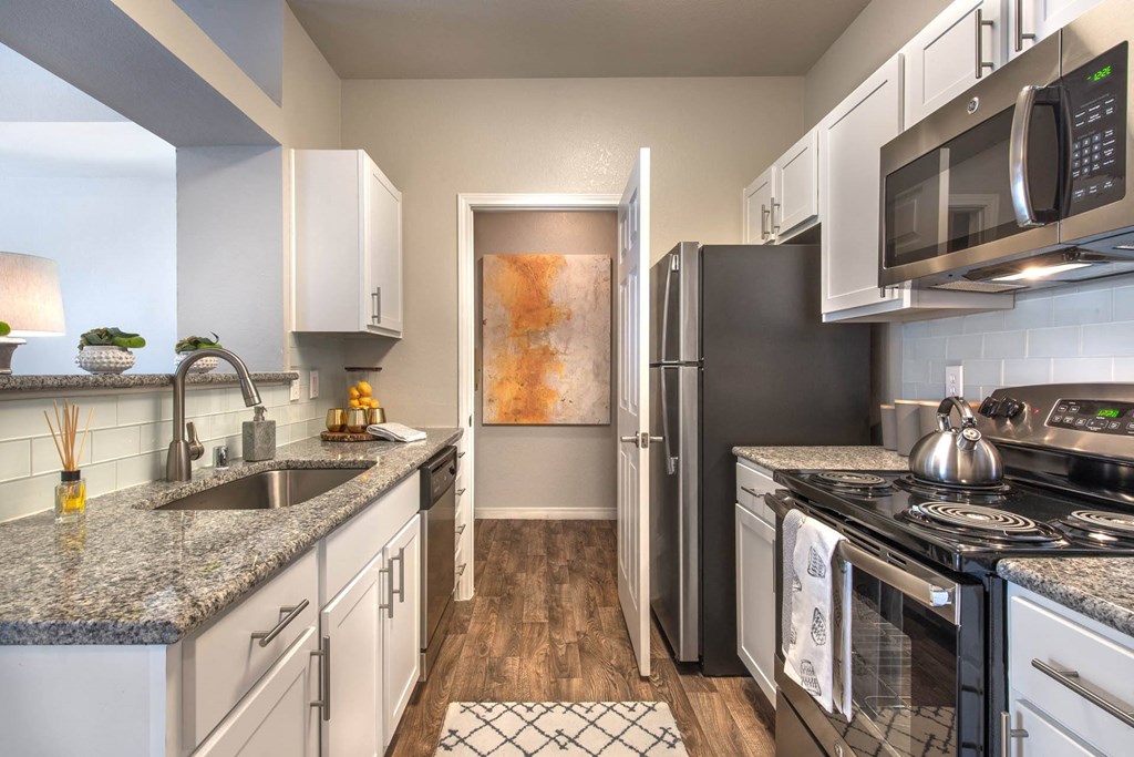 a kitchen with stainless steel appliances and granite counter topsat Creekside at Legacy, Texas