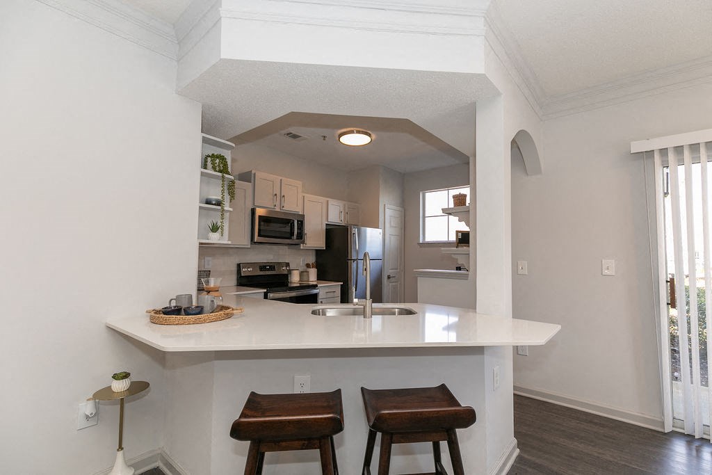a kitchen with a large island and two stools at Deerfield Village, Alpharetta, Georgia