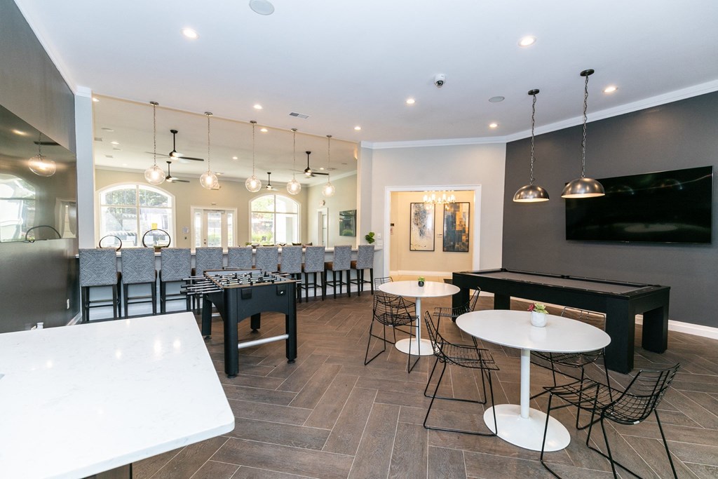 a game room with tables and chairs and a television  at Deerfield Village, Alpharetta, Georgia