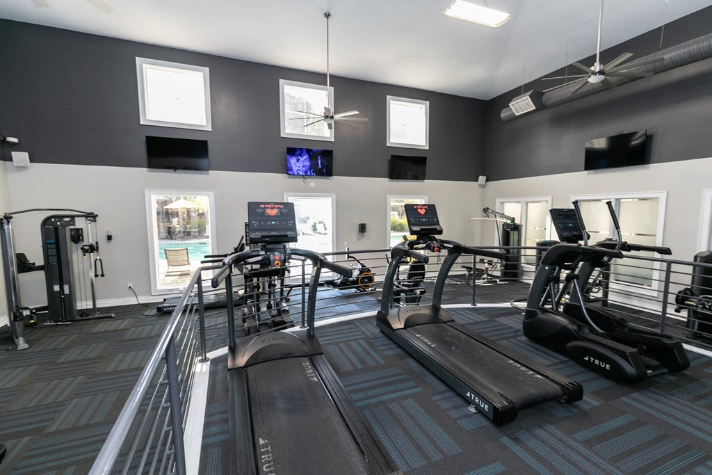 a gym with cardio equipment and windows in a building  at Deerfield Village, Alpharetta