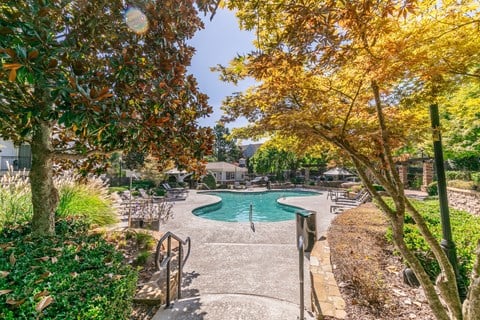 a swimming pool with trees and benches next to it at Deerfield Village, Alpharetta