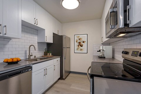 a kitchen with stainless steel appliances and white cabinets