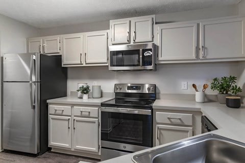 a kitchen with stainless steel appliances and white cabinets at Gwinnett Pointe, Norcross, Georgia