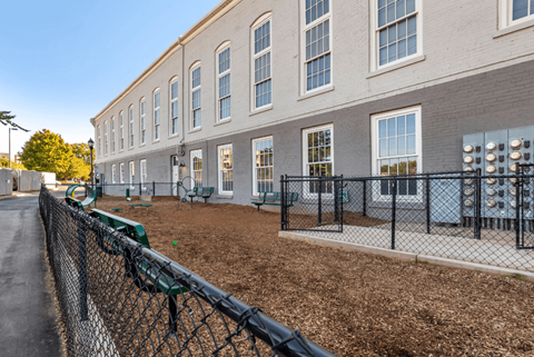 a building with a fenced in yard and a chain link fence at Highland Mill Lofts, Charlotte, NC