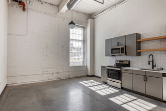 a kitchen with white walls and stainless steel appliances and a window
