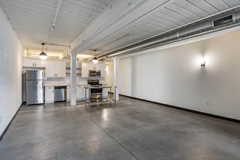 an empty room with a kitchen and a table in the middle at Highland Mill Lofts, Charlotte, North Carolina