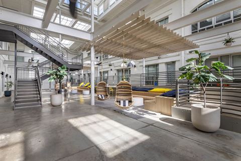 the lobby of an office building with stairs and plants