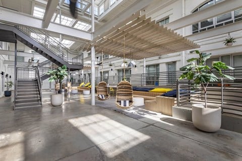 the lobby of an office building with stairs and plants at Highland Mill Lofts, Charlotte, NC
