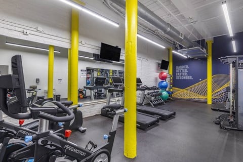 a gym with cardio equipment and weights in a building at Highland Mill Lofts, Charlotte