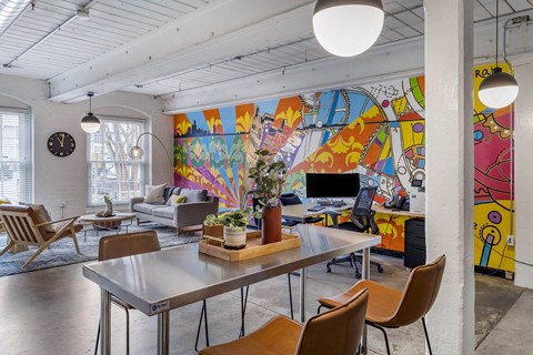 a living room with a table and chairs and a mural on the wall at Highland Mill Lofts, Charlotte, North Carolina
