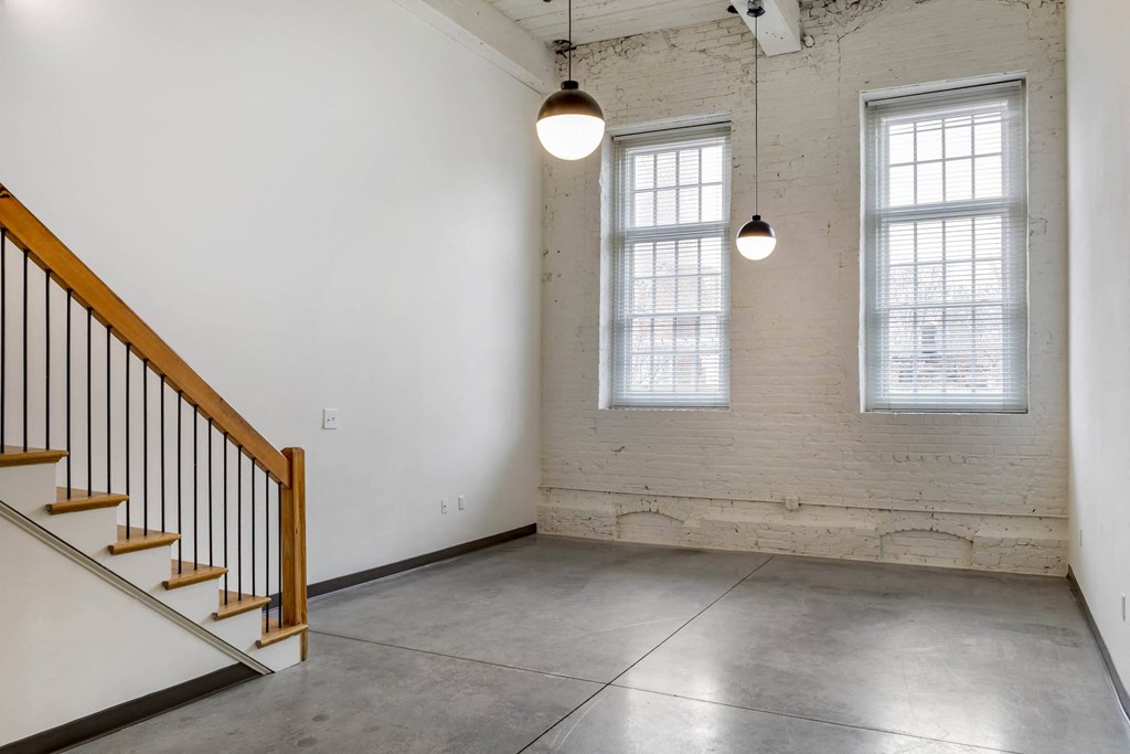 an empty room with two windows and a staircase at Highland Mill Lofts, Charlotte, North Carolina