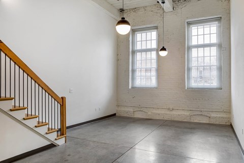 an empty room with two windows and a staircase at Highland Mill Lofts, Charlotte, North Carolina