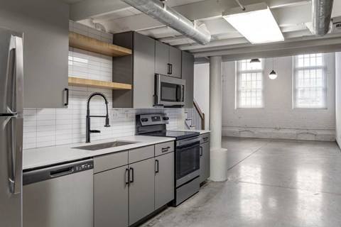 a kitchen with white counter tops and stainless steel appliances at Highland Mill Lofts, Charlotte, 28205