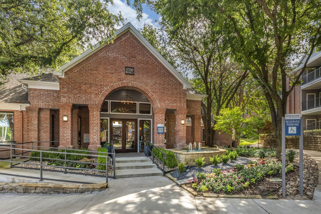 the front of a brick building with trees and a sidewalk at Lakeshore at Preston, Texas