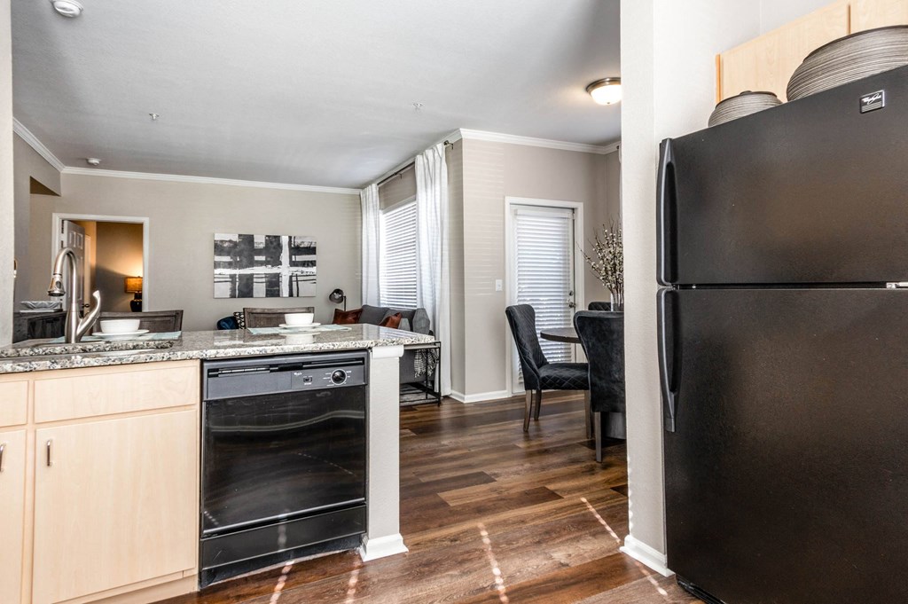 a kitchen and living room with a refrigerator and a sink at The links at Plum Creek Apartments, Colorado