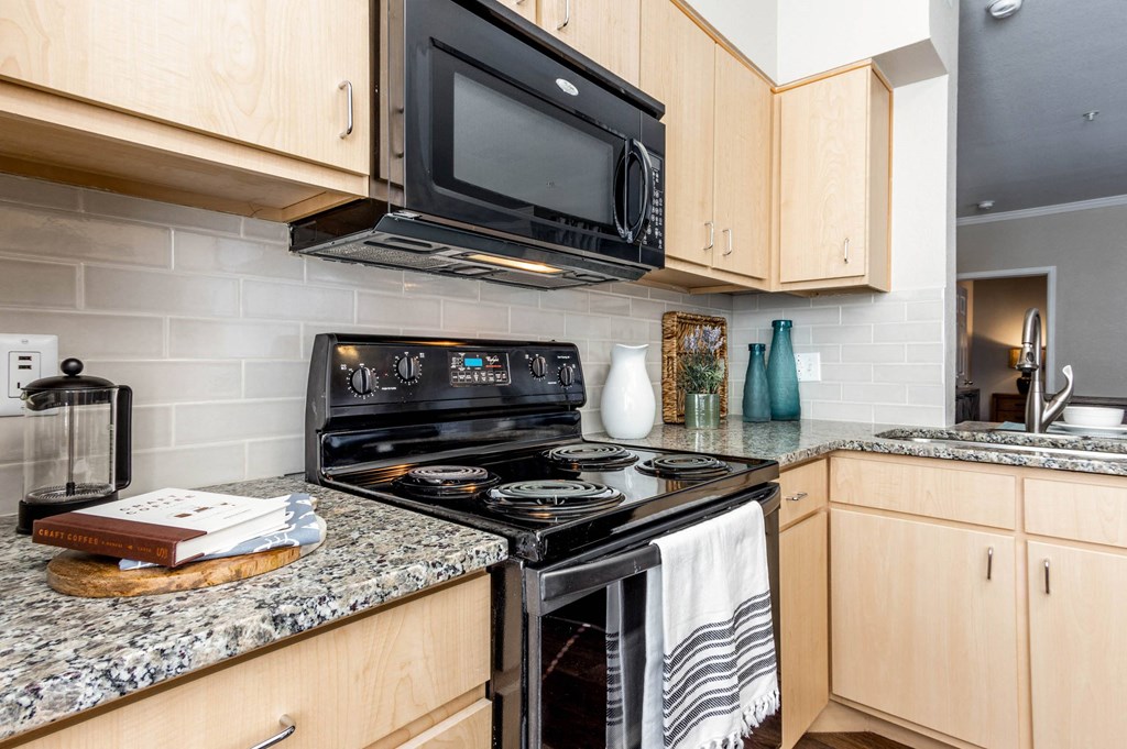 a kitchen with black appliances and granite counter top