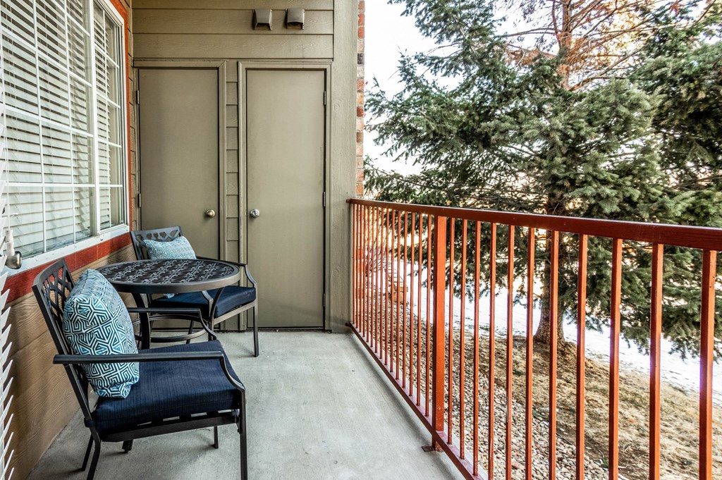 a balcony with a table and chairs and a door to a patio at The links at Plum Creek Apartments, Castlerock