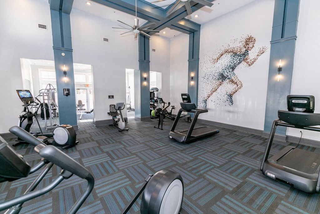 a workout room with weights and a mural of a woman on the wall at Roswell Village, Roswell, GA, 30075