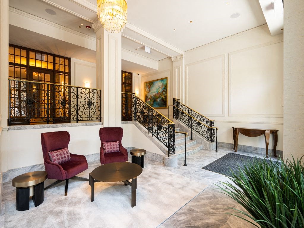 a lobby with chairs and a staircase  at The Belden Stratford, Chicago, IL