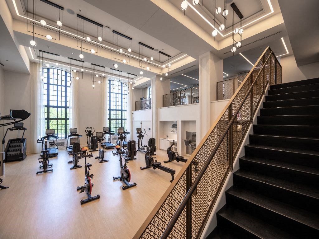 a gym with cardio machines and weights on a wooden floor  at The Belden Stratford, Chicago, Illinois
