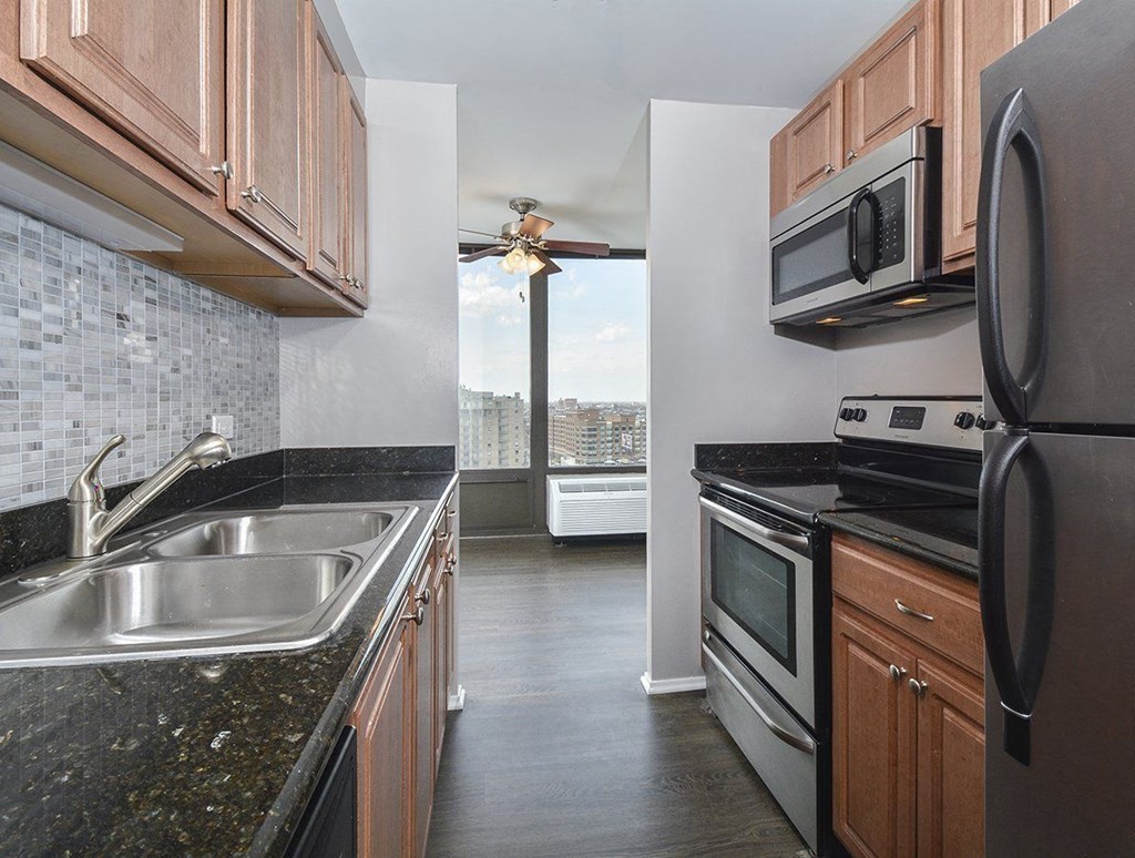 a kitchen with granite counter tops and stainless steel appliancesat The Montrose, Chicago