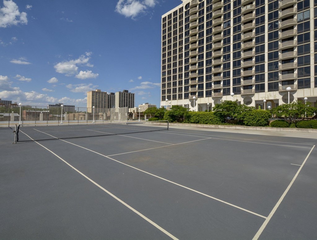 an empty tennis court in front of a tall building at The Montrose, IL 60613
