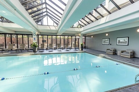 a swimming pool with a glass ceiling and chairs at North Harbor Tower, Chicago