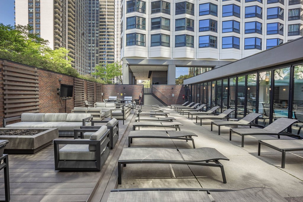a row of lounge chairs on a patio next to a building at North Harbor Tower, Illinois, 60601
