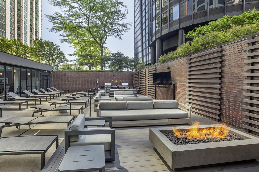 a lounge area with couches and tables and a fire pit at North Harbor Tower, Illinois