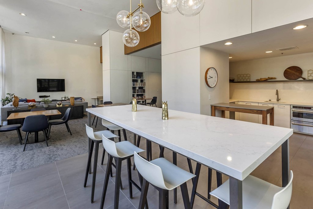a long white table in the center of a kitchen and living room at North Harbor Tower, Chicago, 60601
