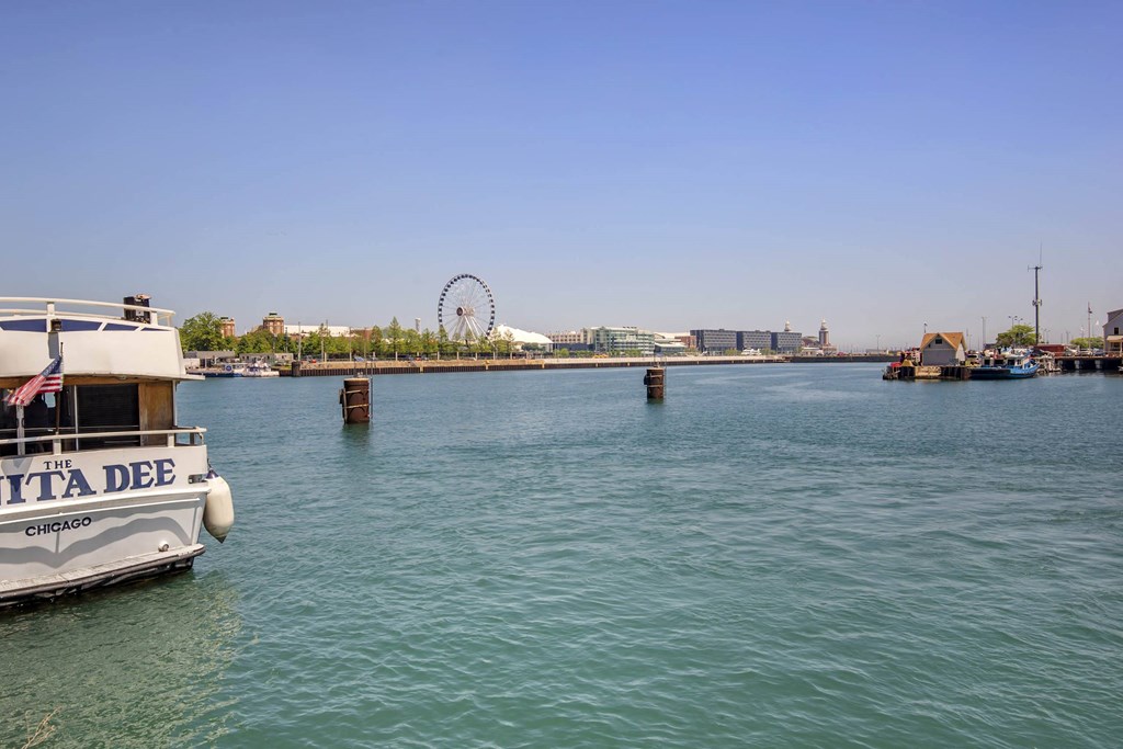 a boat in the water with a ferris wheel in the background at North Harbor Tower, Chicago, 60601