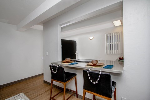 a kitchen with a counter top and two chairs