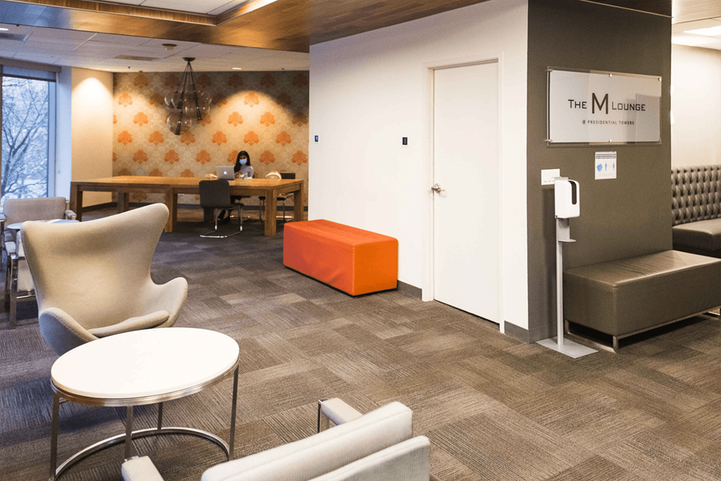 a room with couches and chairs and a table with a orange stool at Presidential Towers, Chicago, IL