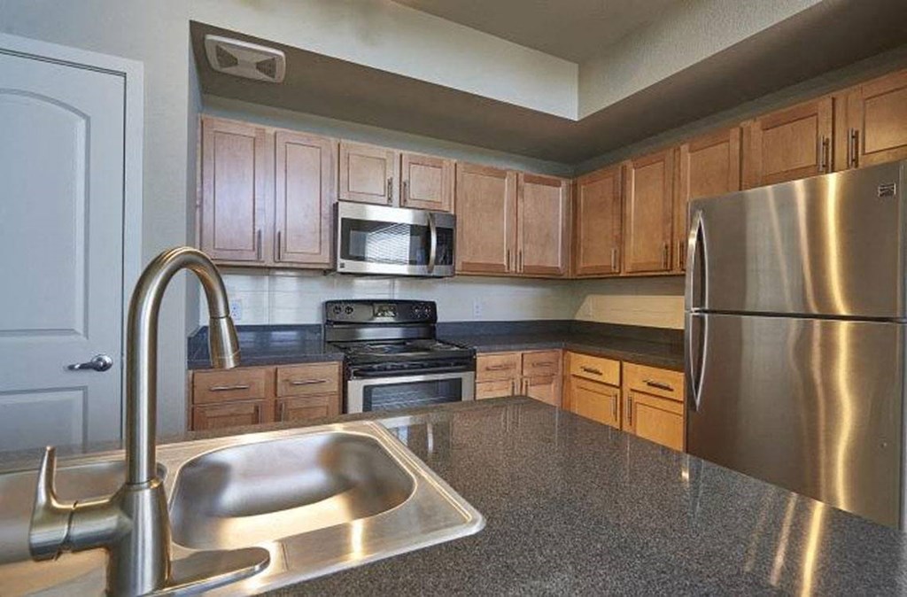 a kitchen with stainless steel appliances and a sink at Ridge at Thornton Station Apartments, Thornton, CO 80229
