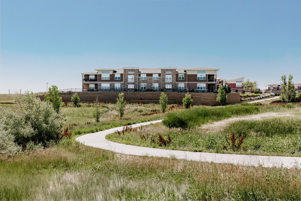 a path leading to a building in a field at Ridge at Thornton Station Apartments, Colorado
