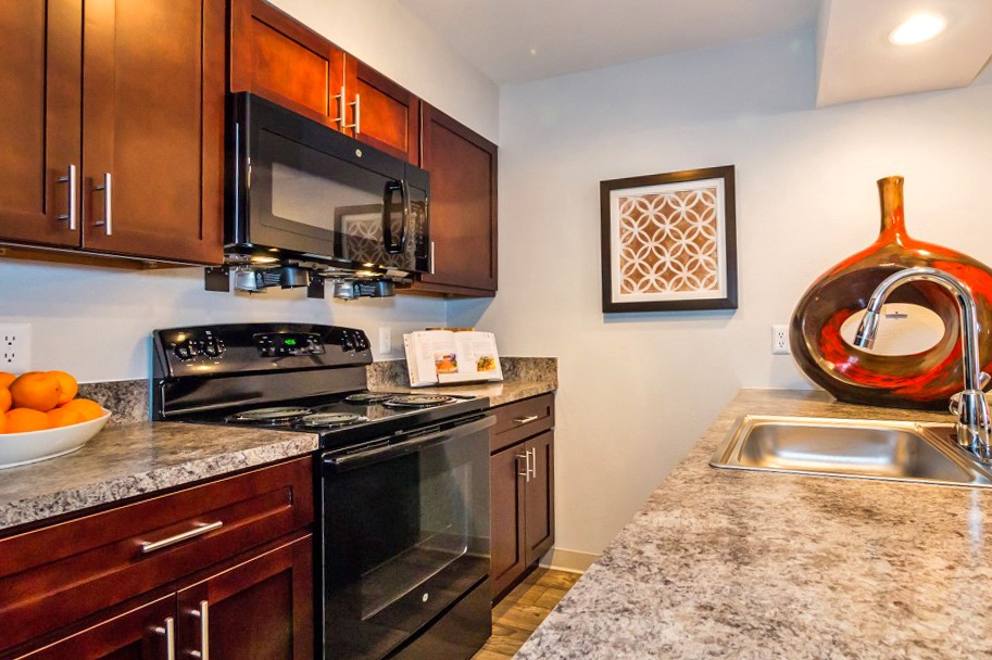 a kitchen with black appliances and granite counter tops at Apartments at Denver Place, Denver, 80202