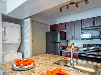 full kitchen with stainless steel appliances and granite counter tops and a sink at Apartments at Denver Place, Denver, CO 80202