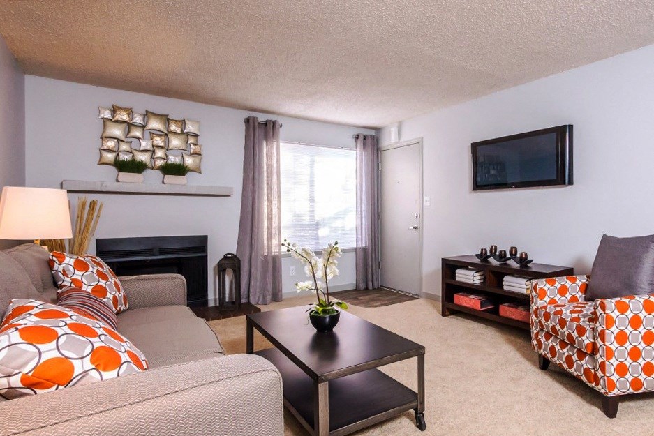 a living room with a couch and a chair and a television at Skyview Apartments, Westminster Colorado