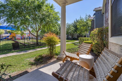a porch with two chairs and a table and a playground in the background at Sladestone Shadow Creek, Pearland, TX, 77584