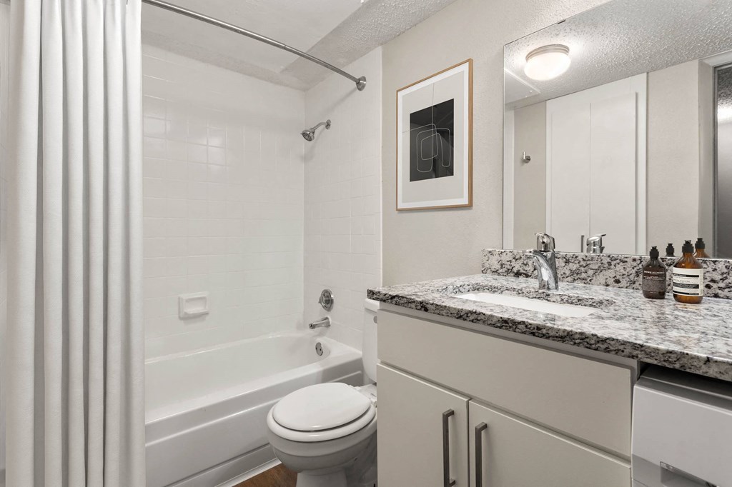 a bathroom with a tub and a sink and a toilet at South Lamar Village, Texas