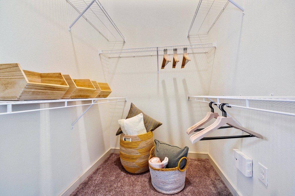 a walk in closet with shelves and pillows and baskets at South Side Flats, Dallas, Texas