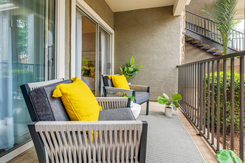 a balcony with a couch and chairs on it