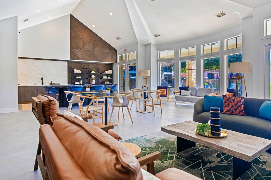 a living room with couches and chairs and a kitchen with tables and chairs