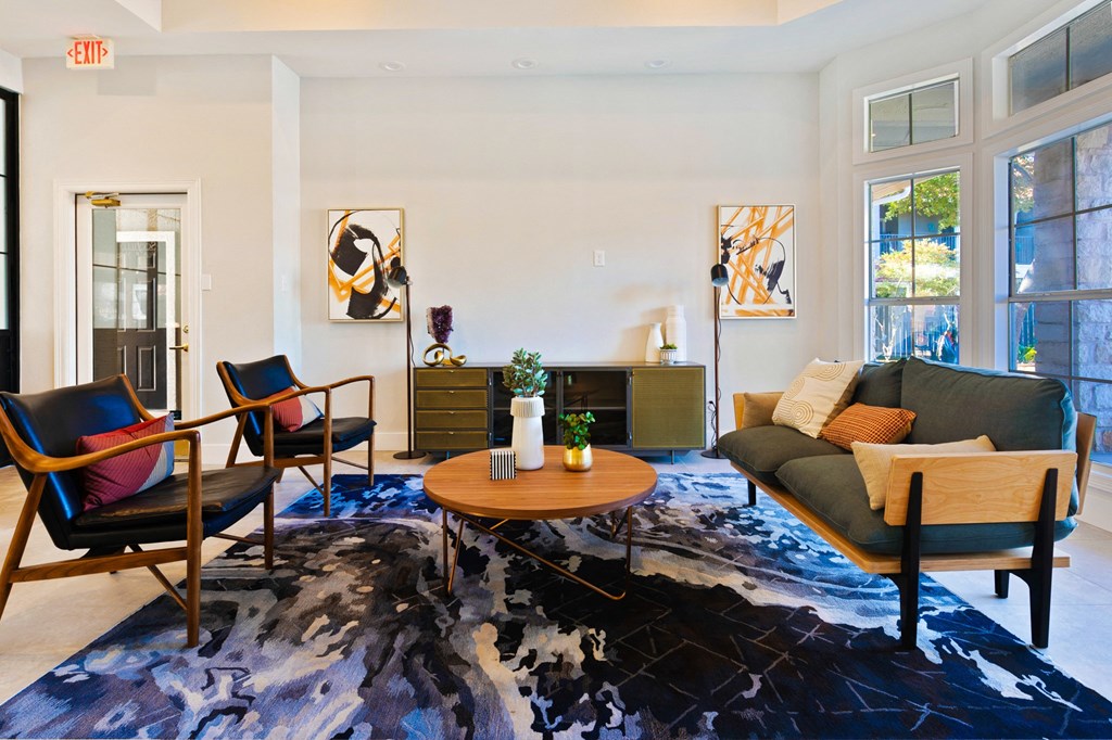 a living room with a couch and chairs and a rug