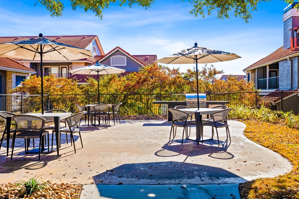 an outdoor patio with tables and umbrellas