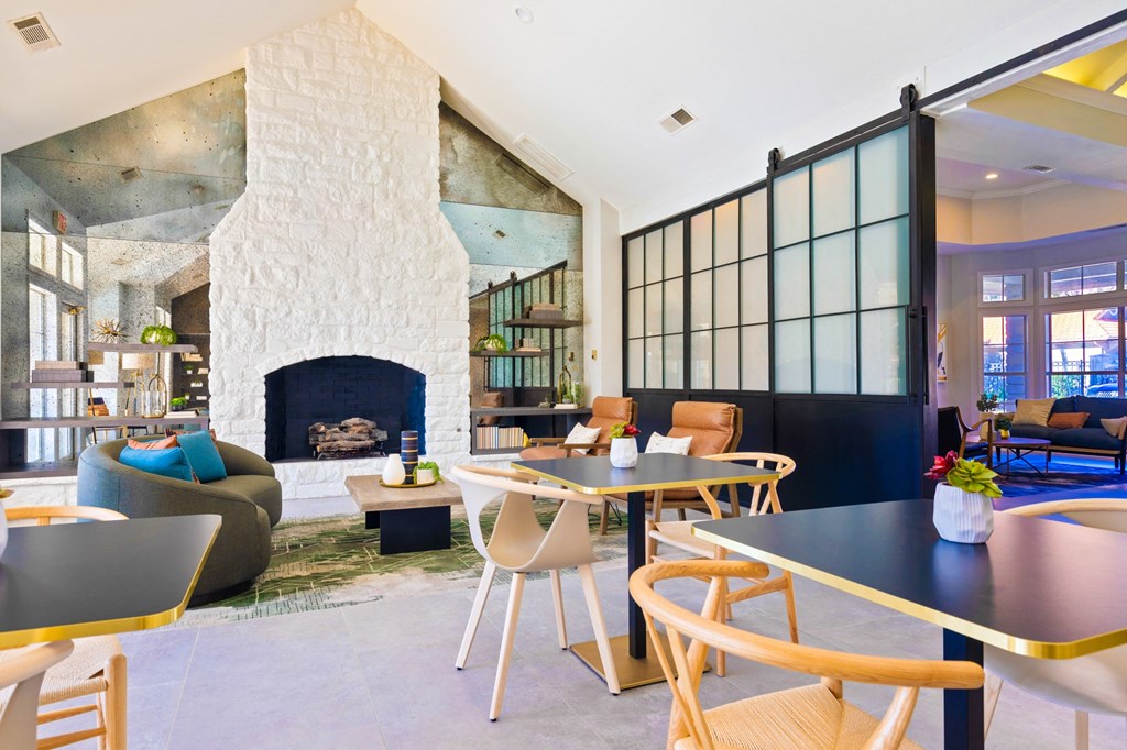 a living room with a fireplace and tables and chairs