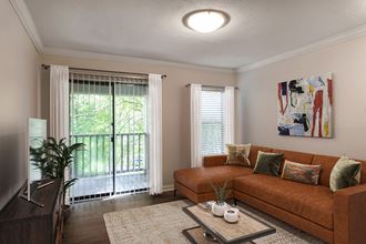 a living room with a brown couch and a sliding glass doo at The Annaline, Nashville, 37217r