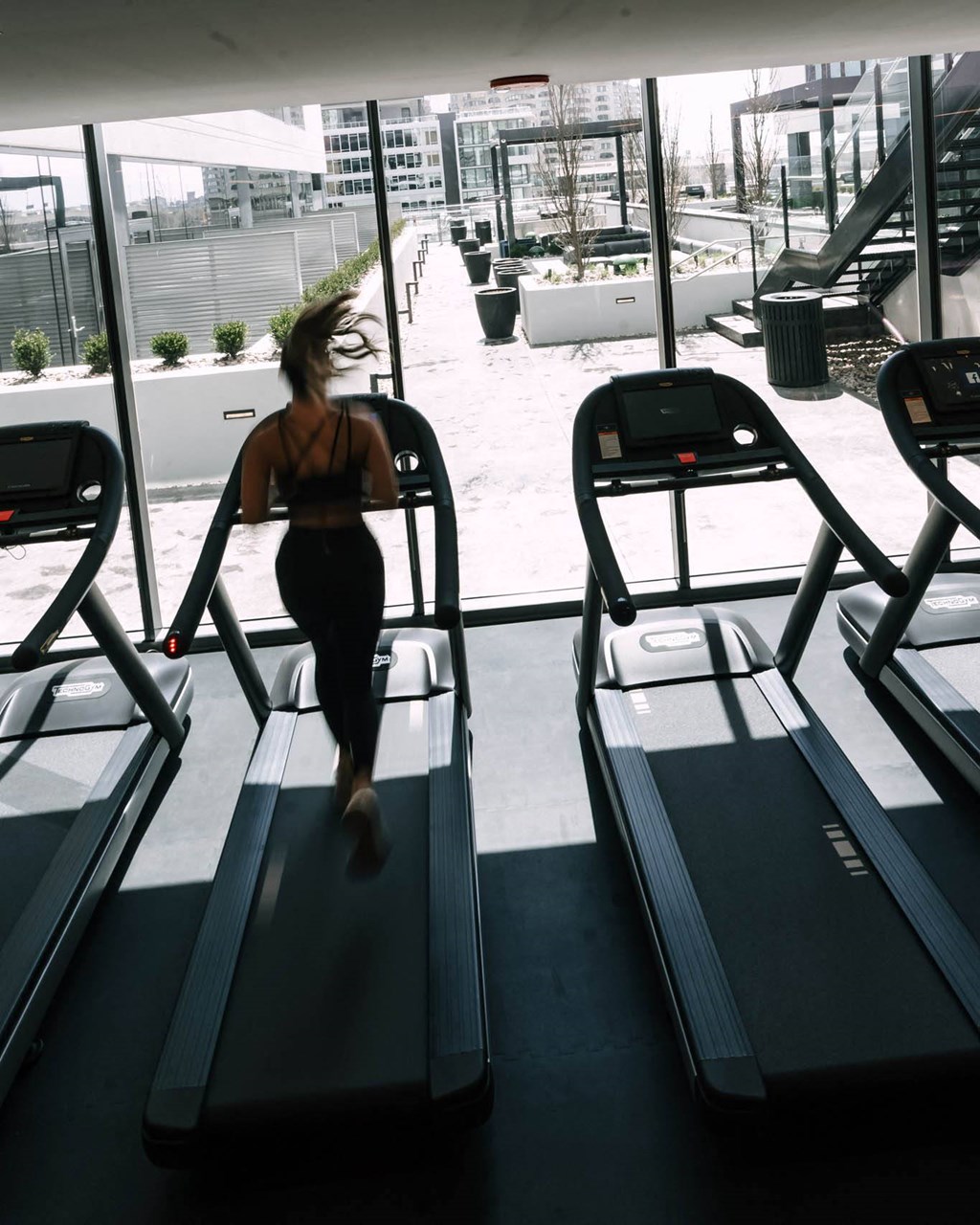 a woman running on a treadmill at the gym at The Grand Central, Chicago, 60607