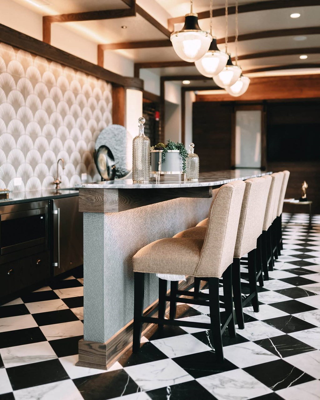 a long bar with chairs with a checkered floor at The Grand Central, Chicago, IL