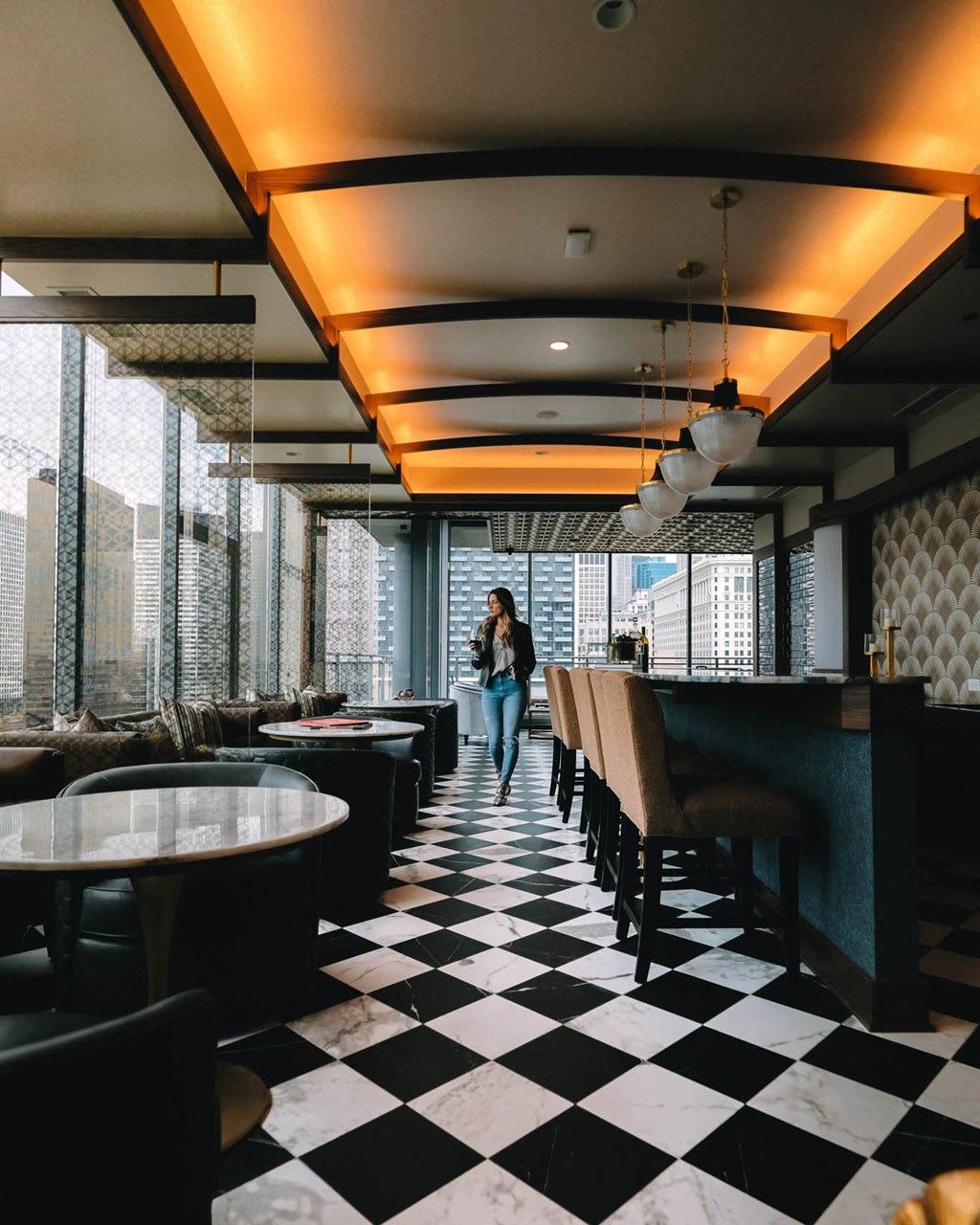 a woman walking down a black and white checkered floor at The Grand Central, Chicago, 60607